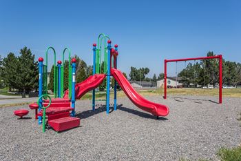 Colorful community playground with two slides and a swing set.